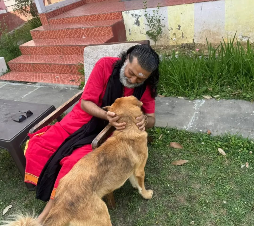Guruji sitting with a dog outdoors